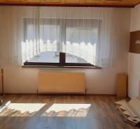 Interior of a room with parquet flooring, a window with a curtain, and a radiator – Apartment construction.