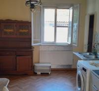 A kitchen with a sink, furniture, a washing machine, and tiles. Apartment construction.