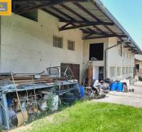 Exterior of Gastro premises in Grossinzersdorf with stored materials and a motorcycle in the yard.