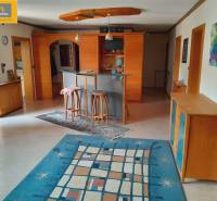 Interior of a gastro space with a table, chairs, and a vibrant colored carpet.