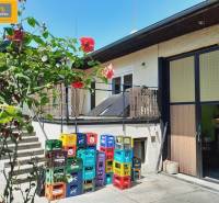 Flower-filled gastro spaces in Grossinzersdorf, with colorful crates in the yard next to the building.