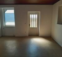 An empty interior with white walls, tiles, and a closed window in commercial premises.