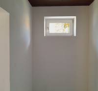 A small window in narrow commercial premises, white walls, dark ceiling.