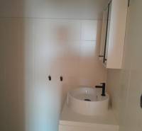 Bathroom commercial spaces with a sink and cabinet in neutral tones.