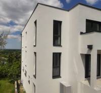 A white facade of a villa in Hainburg an der Donau with modern black windows.