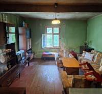 Living room in a cottage with a sofa, coffee table, and retro TV.
