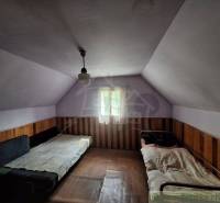 The interior of a cabin with two beds and wooden paneling, dim lighting.