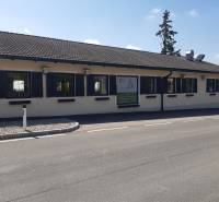 The exterior of the building on Hornerstraße with dining spaces and parking in front of the entrance.