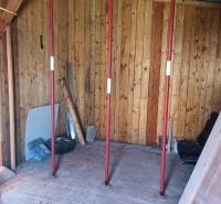 The interior of a cabin with wooden walls and support columns.