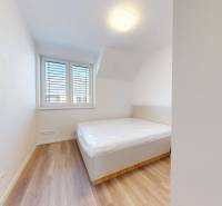 White room with a bed and a window in a family house.