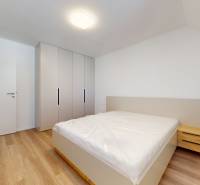 Bedroom in a family house with a bed, built-in wardrobe, and nightstand.