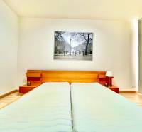 Bedroom with a double bed, wooden headboard, and a painting in a two-room apartment.