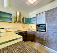 A kitchen in a 2-room apartment with wooden cabinets and built-in appliances.