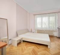 Bedroom in a 3-room apartment with a bed, mirror, and wooden floor.