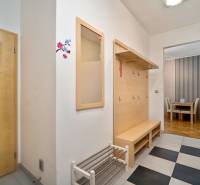 A hallway with a coat rack and a shoe cabinet in a 3-room apartment, leading to the dining room.