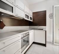 A kitchen in a 3-room apartment with white cabinets and built-in appliances.