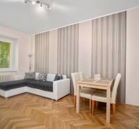 Living room with a corner sofa, table, and parquet flooring in a 3-room apartment.