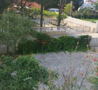 The garden of a family house in Vrsi with paving, greenery, and flowers.