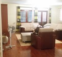 Living room in a family house with a comfortable sofa set and a fan.