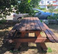 A wooden picnic table in the shade in the garden of a family house in the town of Vrsi.