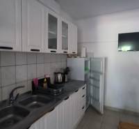 A kitchen in a family house with white cabinets, a stove, and a refrigerator.