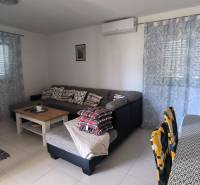 Living room with a sofa, table, and dining table in a family house.