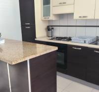 A kitchen in a family house with a kitchen unit, a bar counter, and built-in appliances.
