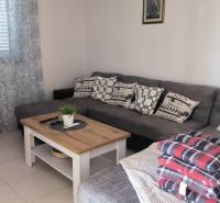 Comfortable corner sofa with cushions in the living room of a family house.