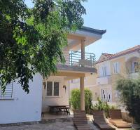 A family house in Vrsi with a terrace, benches, and greenery in the surroundings.