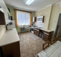 Kitchen in a family house with a dining table, cabinets, and a large window.