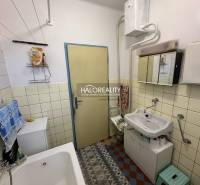 Bathroom in a family house with a sink, bathtub, and storage space.