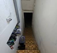 The staircase leads to the basement in the family house, and there are things placed on the stairs.