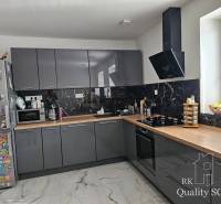 A kitchen in a family house with dark cabinets, appliances, and a decorative magnetic refrigerator.
