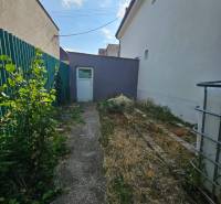 Family house on Rybničná Street in Veľká Mača, narrow yard with greenery and a concrete walkway.