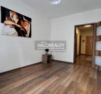 A bright room in a 2-room apartment with wooden flooring and a painting.