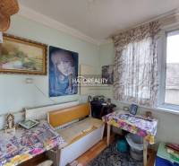 Placement of a table and chairs by the window in a family house with decorations and paintings.