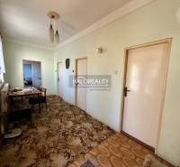 Interior of a family house with a hallway, table, chairs, and carpet.