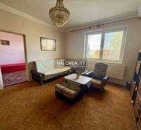 Living room of a family house with a sofa, armchairs, and a chandelier.