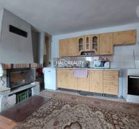 A kitchen with a fireplace and wooden kitchen cabinets in a family house.