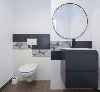 A bathroom in a 3-room apartment with modern ceramics and a round mirror.