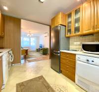 A kitchen in a 3-room apartment with wooden furniture and built-in appliances.