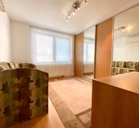 Interior of a room with a sofa, built-in wardrobe, and window in a 3-room apartment.