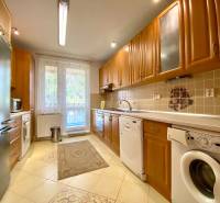 A spacious kitchen in a 3-room apartment with wooden cabinets and appliances.