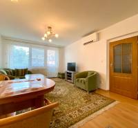 Living room in a three-room apartment with a sofa and a dining table.