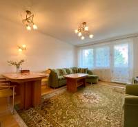 Spacious living room with a green carpet and a sofa in a 3-room apartment.