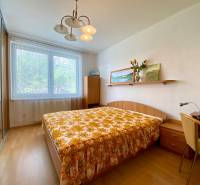 Bedroom in a 3-room apartment with a large window, bed, and built-in wardrobe.
