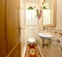 Bathroom with a mirror, sink, and wooden door in a 3-room apartment.