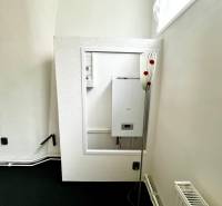 A corner with a boiler, radiator, and electrical connection in commercial premises.