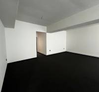 Empty commercial spaces with dark flooring and white walls.