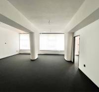 Spacious commercial premises with black carpet and white walls, unfurnished.